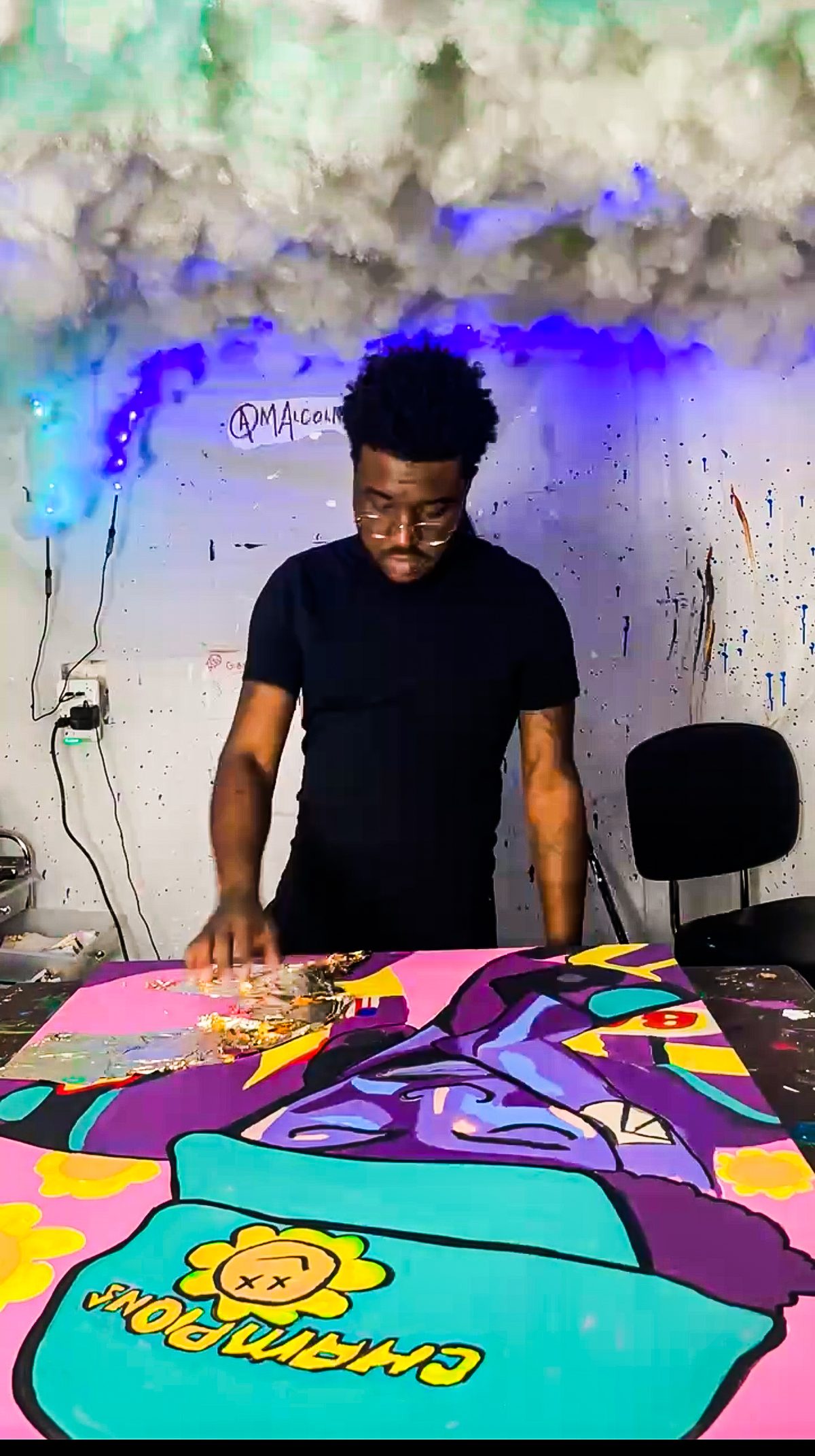 Malcolm Xavier Davis applying gold leaf to a painting in his studio.